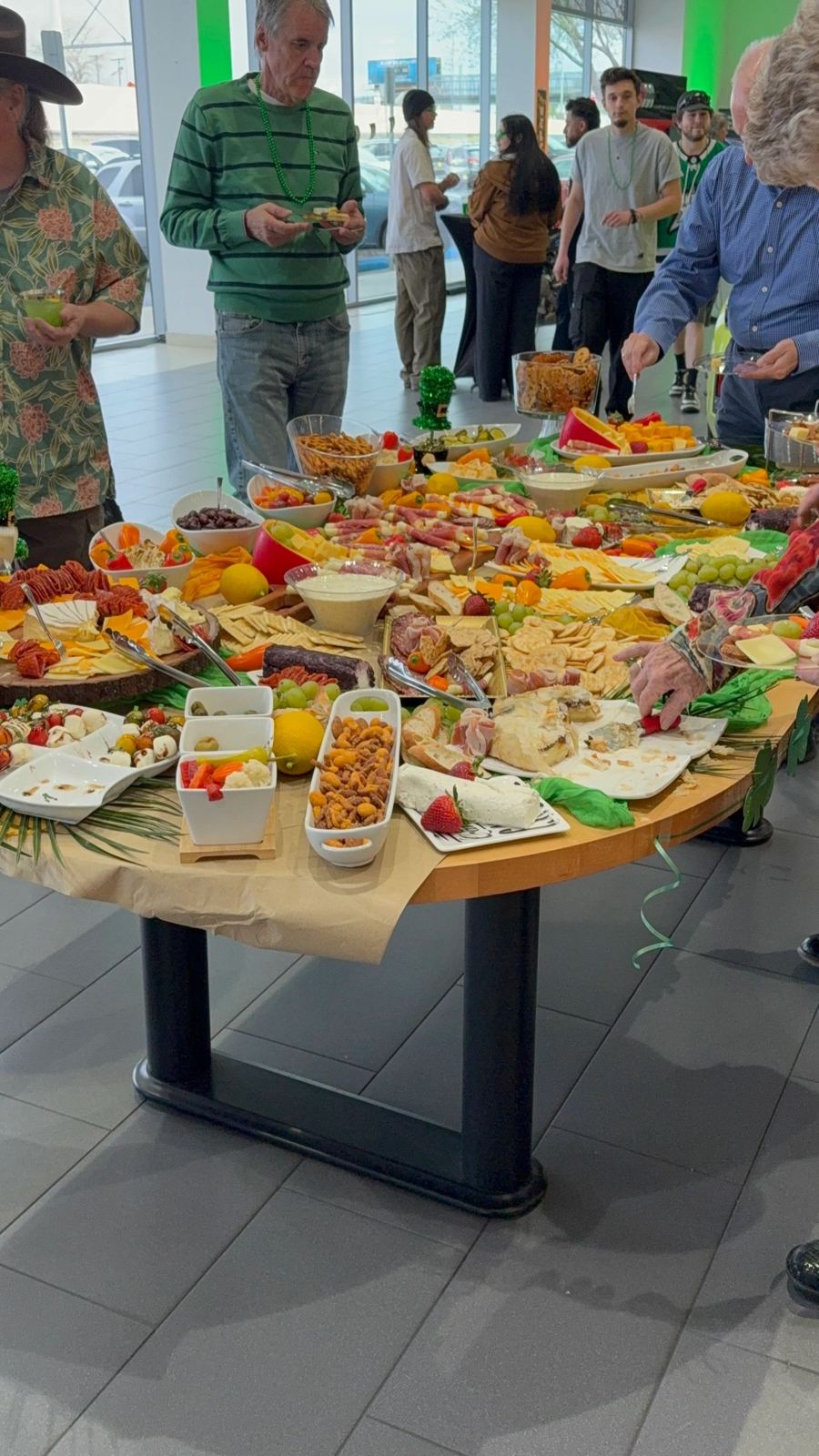 Guests serving themselves from a full grazing table at an event