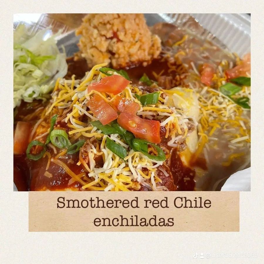 Smothered red chile enchiladas topped with cheese, tomatoes and green onions, from Stuffed Lust's own menu cards