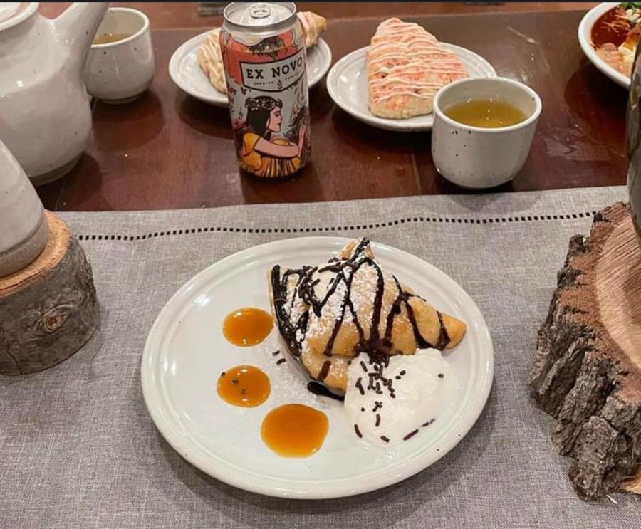 Plated dessert sopapilla with chocolate drizzle and ice cream beside an Ex Novo beer