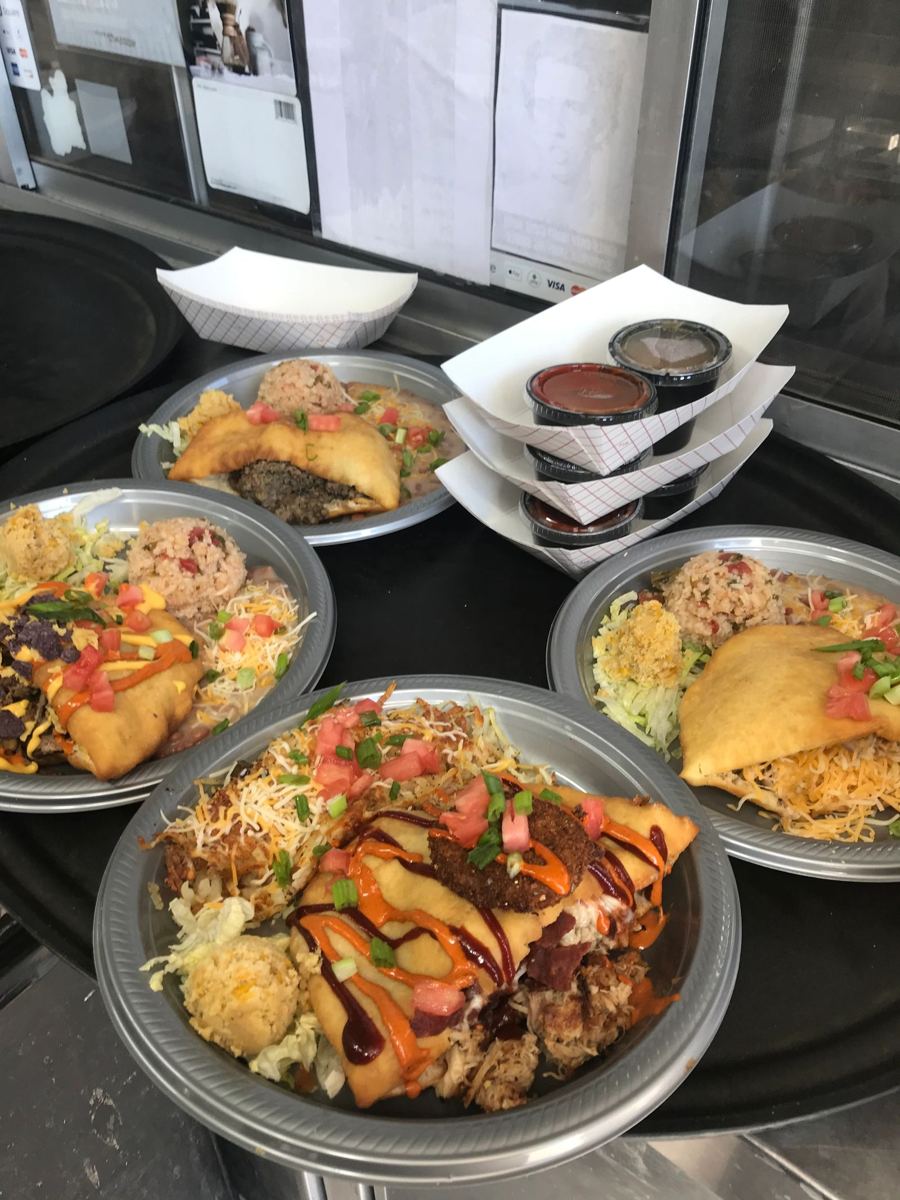 Plates with red and green chile drizzle lined up in the service window